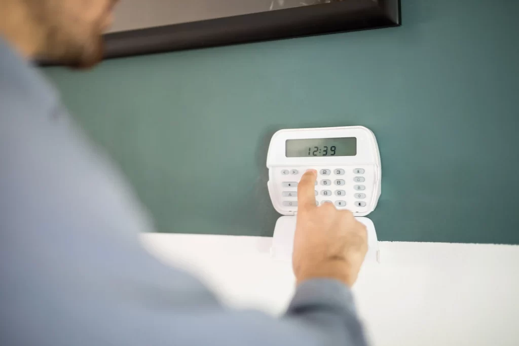 Man Using Keypad in Home Alarm System - Intruder Alarm Installation in Dubai